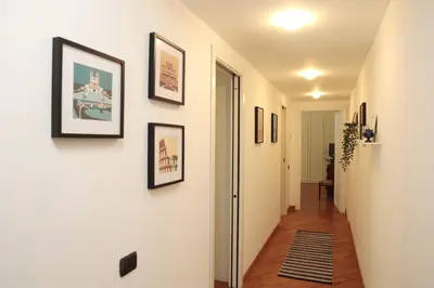 a hallway with pictures on the walls of a house at Luminoso e accogliente appartamento con giardino - Battistini in Rome