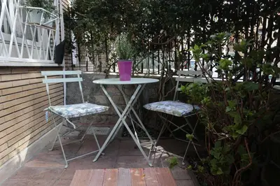a table and two chairs with a purple cup on top at Luminoso e accogliente appartamento con giardino - Battistini in Rome