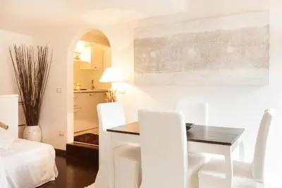a dining room with a table and white chairs at Endless beauty - Charming attic in the heart of Rome in Rome