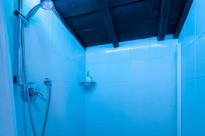 a bathroom with a shower with blue lighting at Endless beauty - Charming attic in the heart of Rome in Rome
