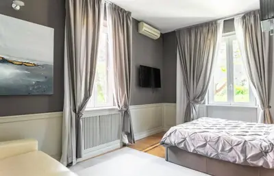 a bedroom with a bed and two windows at Vatican Home 51 in Rome