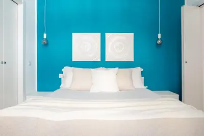a bedroom with blue walls and a bed with white pillows at Parisi apt in Rome