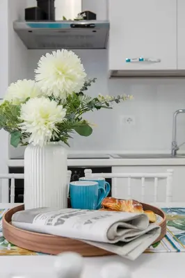 a table with a vase with flowers and a plate of food at Parisi apt in Rome