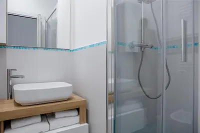 a bathroom with a shower with a sink and a mirror at Parisi apt in Rome
