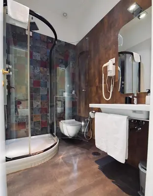 a bathroom with a sink and a mirror and a bed at Suites Farnese Design in Rome