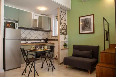 a kitchen and dining room with a table and chairs at Ton Ton by Ghor in Rome