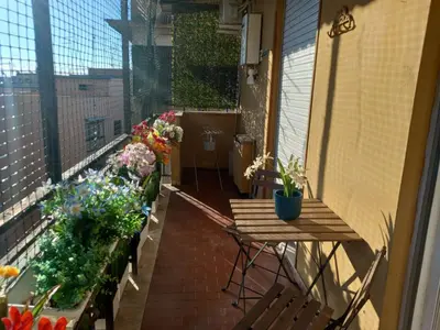 a balcony with a table and flowers on it at La Casa Libre Metro A Colli Albani 350 m in Rome