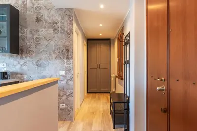 a corridor of a kitchen with a door to a hallway with a table at GuestHost - Valle Aurelia Elegant Apartment in Rome