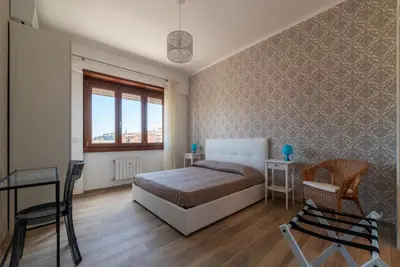 a bedroom with a bed and a table and chairs at GuestHost - Valle Aurelia Elegant Apartment in Rome