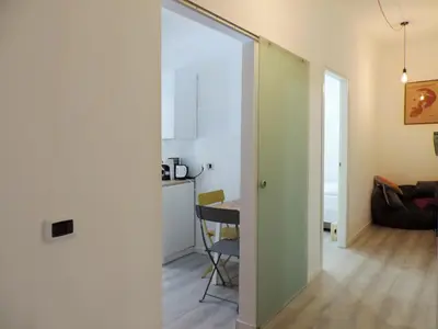 a room with a table and a door leading to a kitchen at Kalu apartment in Rome