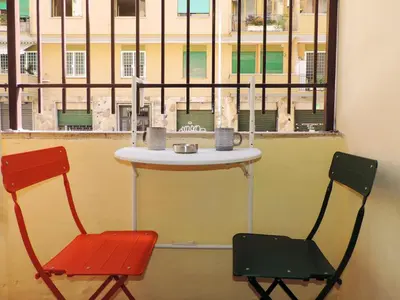 two chairs sitting next to a table in front of a window at Kalu apartment in Rome
