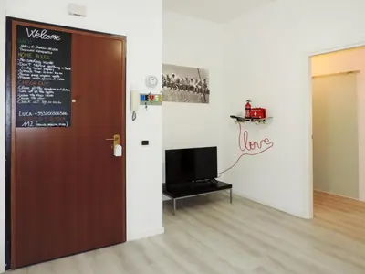 a room with a door and a tv and a wall at Kalu apartment in Rome