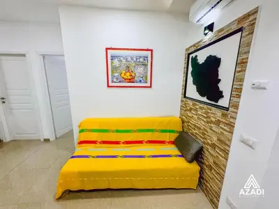 a yellow couch in a room with a wall at Azadi B&B Flaminio in Rome