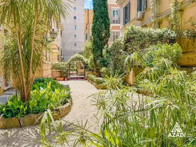 a garden with palm trees and plants in a building at Azadi B&B Flaminio in Rome