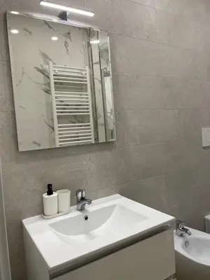 a bathroom with a white sink and a mirror at [COLOSSEUM] Latin Romans Apartments in Rome