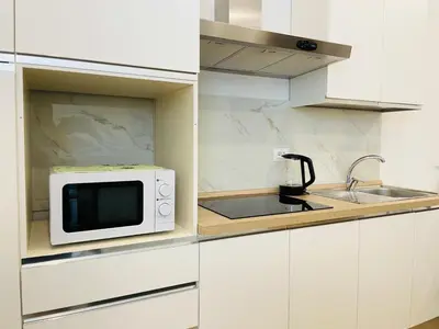 a white kitchen with a microwave and a sink at [COLOSSEUM] Latin Romans Apartments in Rome