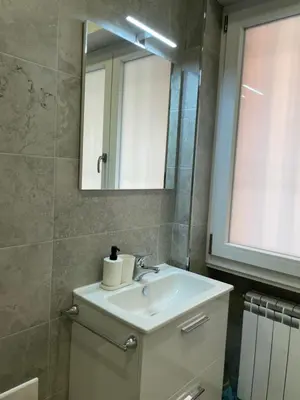 a bathroom with a sink and a mirror at [COLOSSEUM] Latin Romans Apartments in Rome