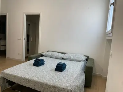 two blue towels sitting on a bed in a room at [COLOSSEUM] Latin Romans Apartments in Rome