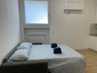 a bedroom with a bed with two blue towels on it at [COLOSSEUM] Latin Romans Apartments in Rome