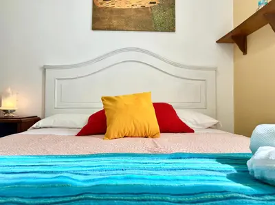 a bed with two red and yellow pillows on it at 3 min da Stazione San Pietro in Rome