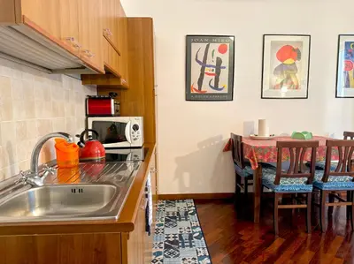 a kitchen with a sink and a table with a dining room at 3 min da Stazione San Pietro in Rome