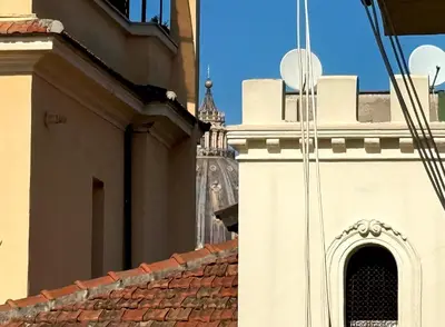 a building with a clock tower in the background at 3 min da Stazione San Pietro in Rome