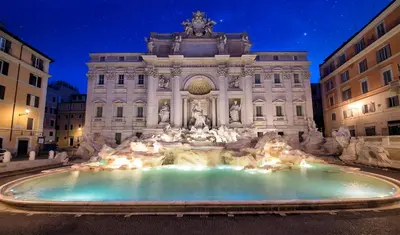 a fountain in front of a building at night at 3 min da Stazione San Pietro in Rome