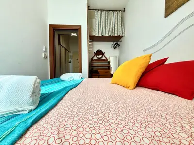 a bedroom with a bed with colorful pillows on it at 3 min da Stazione San Pietro in Rome