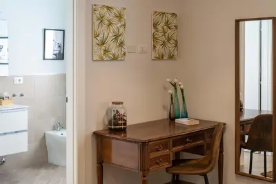 a bathroom with a wooden desk with a vase of flowers on it at Ary's Vatican Holiday Home in Rome