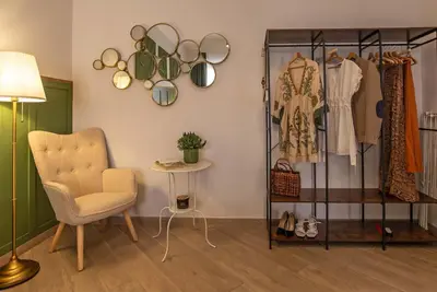 a room with a chair and a rack of clothes at Ary's Vatican Holiday Home in Rome