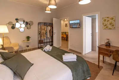 a bedroom with a large bed and a desk and a dining room at Ary's Vatican Holiday Home in Rome