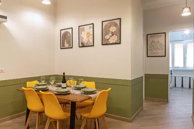 a dining room with a table and yellow chairs at Ary's Vatican Holiday Home in Rome
