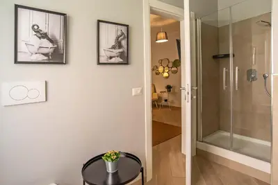 a bathroom with a glass shower and a table at Ary's Vatican Holiday Home in Rome