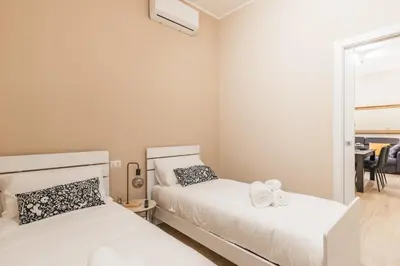 two beds in a small room with a mirror at Italy House in Rome