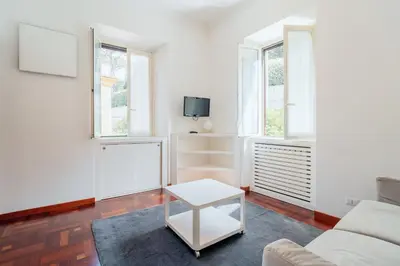a living room with a couch and two windows at Art House Vaticano Apartment in Rome