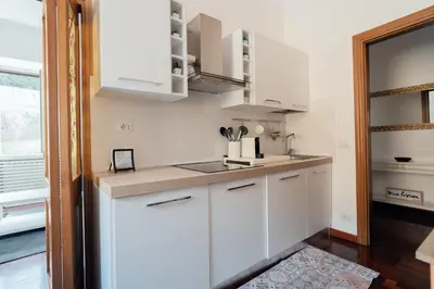 a kitchen with white cabinets and a sink at Art House Vaticano Apartment in Rome