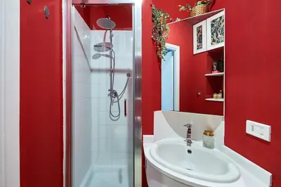 a red bathroom with a sink and a shower at La Dolce Vita Rooftop Suite in Rome