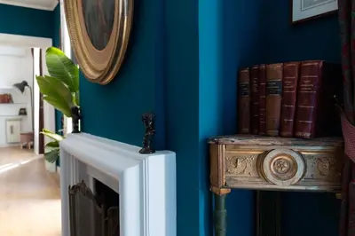 a room with blue walls and a table with books at La Dolce Vita Rooftop Suite in Rome