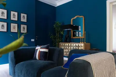 a blue living room with two blue chairs and a mirror at La Dolce Vita Rooftop Suite in Rome