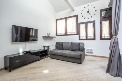 a living room with a couch and a clock on the wall at Trastevere Double A LOFT in Rome