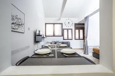 a white dining room with a table and chairs at Trastevere Double A LOFT in Rome