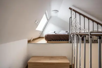 a bedroom with a bed and a stair case at Trastevere Double A LOFT in Rome
