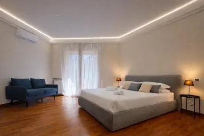 a bedroom with a large bed and a blue couch at èROMA - SAN PAOLO BASILICA Apartment in Rome