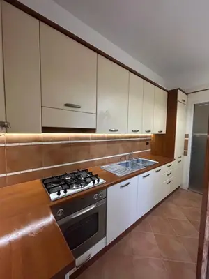 a kitchen with white cabinets and a stove top oven at èROMA - SAN PAOLO BASILICA Apartment in Rome