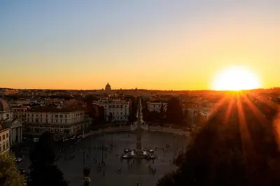 a view of a city with the sun setting at Rome Room Vatican in Rome