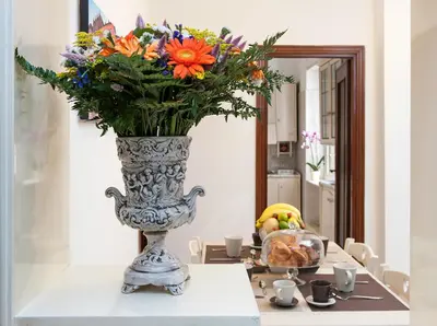 a vase filled with flowers sitting on a table at Residenza dei Pontefici in Rome