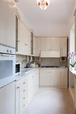 a white kitchen with white cabinets and a chandelier at Residenza dei Pontefici in Rome