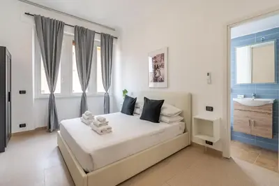 a white bedroom with a bed and a sink at San Giovanni Boutique Suites in Rome