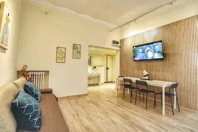 a living room with a table and a tv on a wall at Lovely 2 Bedroom apartment by YourHost in Rome