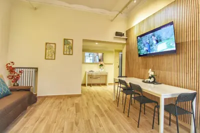 a living room with a table and a tv on a wall at Lovely 2 Bedroom apartment by YourHost in Rome